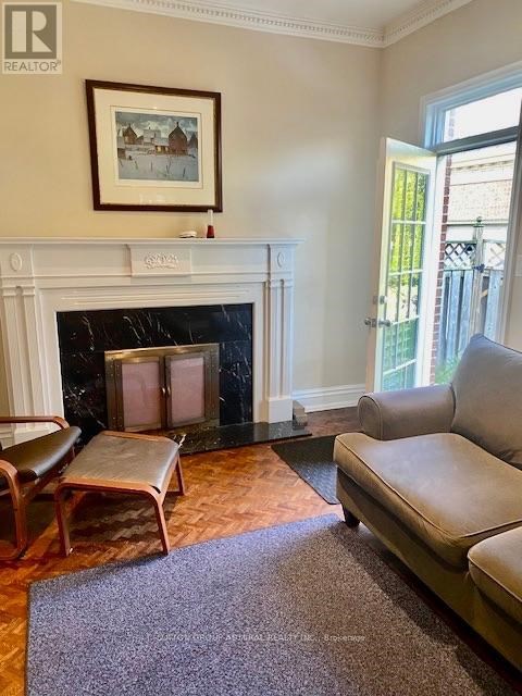 A living room with a fireplace and a painting on the wall.