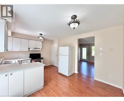 A kitchen with white cabinets and a wooden floor.