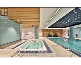 A swimming pool in a room with a wooden ceiling.