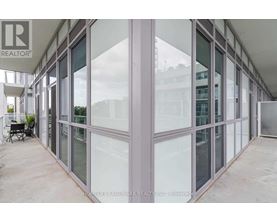A glass wall of a building with a Realtor sign on it.