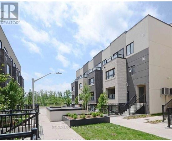 A modern apartment complex with a landscaped courtyard in the foreground.