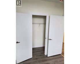 A white door is open to a room with a white wall.