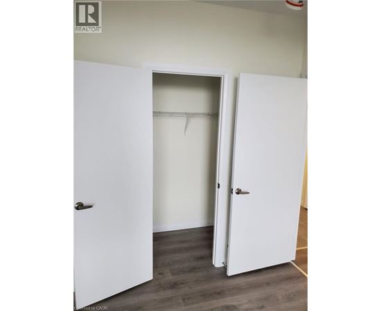 A white door is open to a room with a white wall.