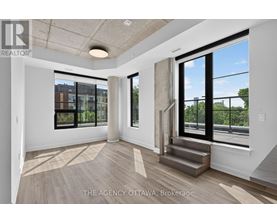 A spacious room with a view of the city through large windows.