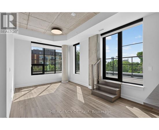 A spacious room with a view of the city through large windows.