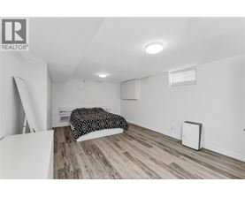 A bedroom with a bed and a small air conditioner unit.
