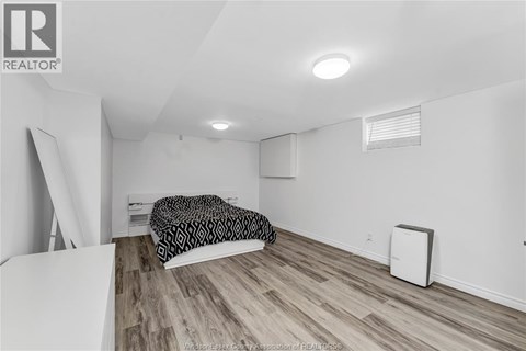 A bedroom with a bed and a small air conditioner unit.