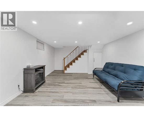 A living room with a blue couch and a wooden floor.