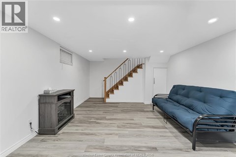 A living room with a blue couch and a wooden floor.