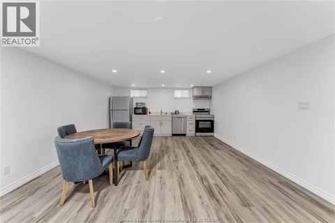 A dining room with a table and chairs.