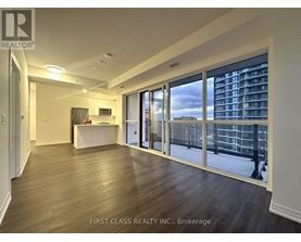 A spacious room with a desk and a large window overlooking a cityscape.