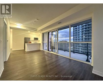 A spacious room with a desk and a large window overlooking a cityscape.