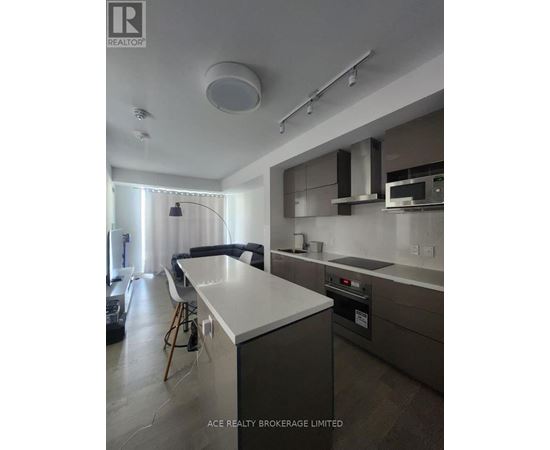 A modern kitchen with a white countertop and stainless steel appliances.
