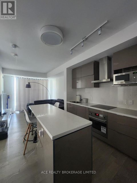 A modern kitchen with a white countertop and stainless steel appliances.