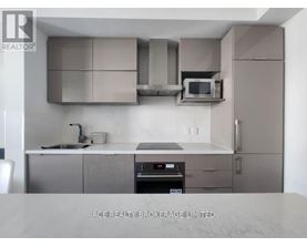 A modern kitchen with stainless steel appliances and a marble countertop.