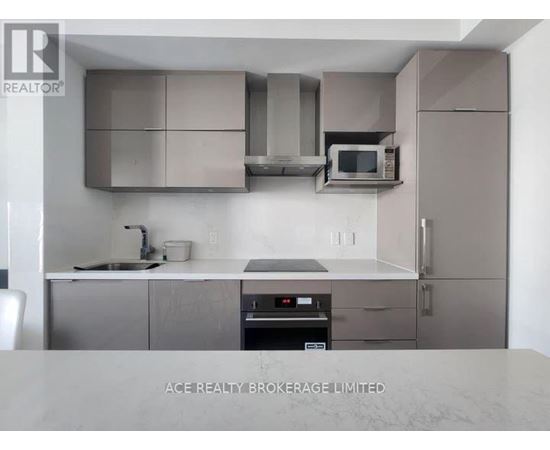 A modern kitchen with stainless steel appliances and a marble countertop.