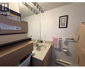A bathroom with a sink, mirror, and towel rack.