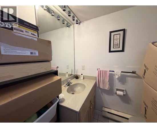 A bathroom with a sink, mirror, and towel rack.