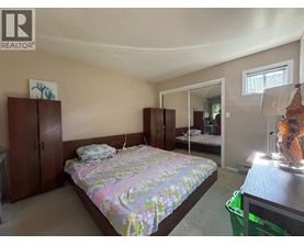 A bedroom with a bed, dresser, and mirror.