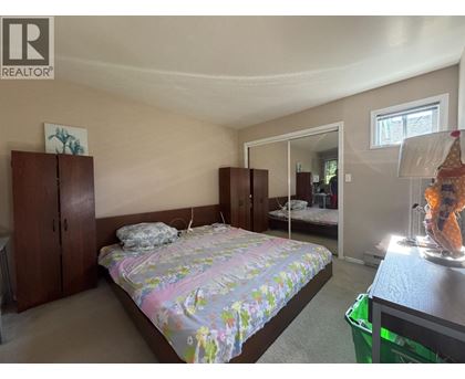 A bedroom with a bed, dresser, and mirror.