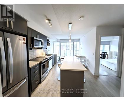 A kitchen with a refrigerator, microwave, and oven.