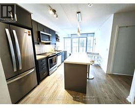 A kitchen with a refrigerator, microwave, oven, and sink.