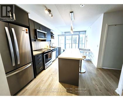 A kitchen with a refrigerator, microwave, oven, and sink.
