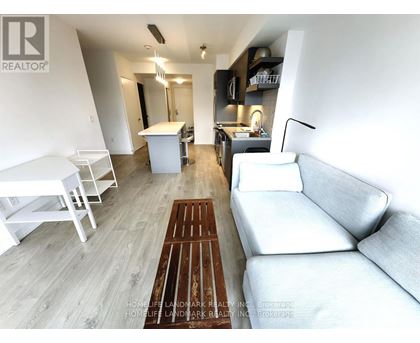 A living room with a white couch and a wooden floor.