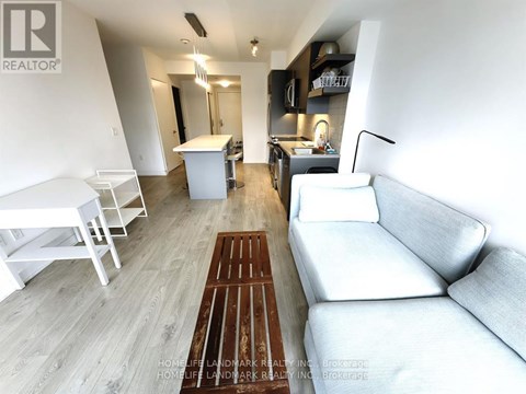 A living room with a white couch and a wooden floor.