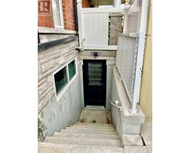 A small staircase leads to a door in a narrow alley.