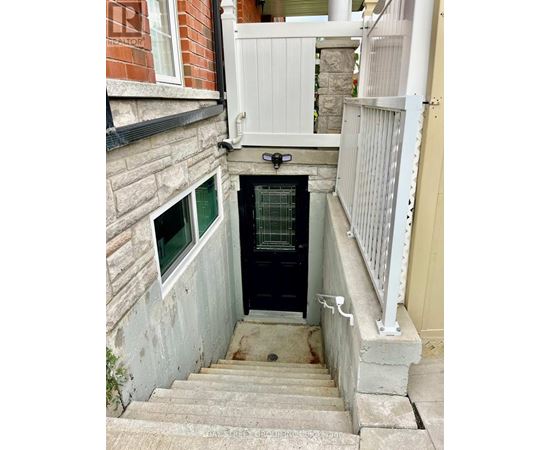 A small staircase leads to a door in a narrow alley.