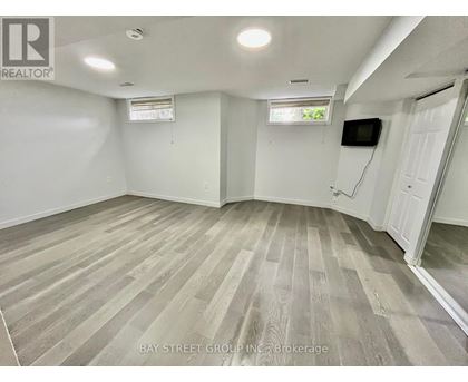 A spacious room with wooden flooring and white walls.