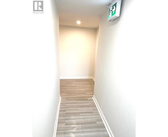 A hallway with a green exit sign on the wall.