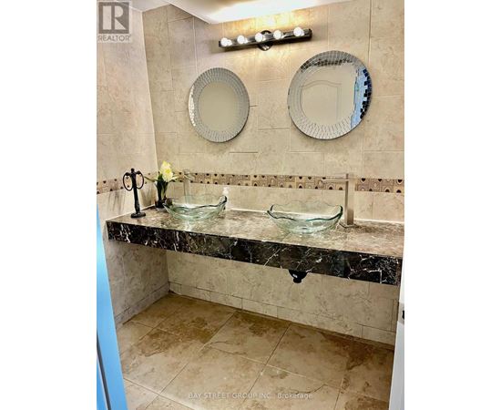 A bathroom with a marble counter top and two mirrors.