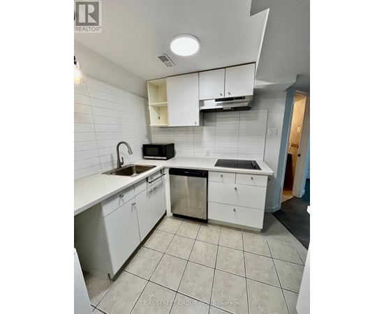 A kitchen with white cabinets and a black dishwasher.
