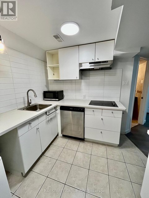 A kitchen with white cabinets and a black dishwasher.