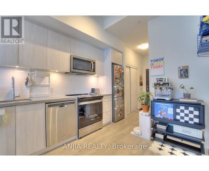A modern kitchen with wooden cabinets and stainless steel appliances.