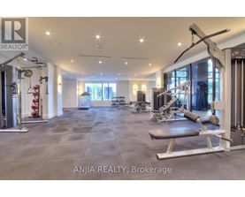 A well-lit gym with a variety of equipment is available for use.
