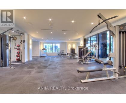 A well-lit gym with a variety of equipment is available for use.