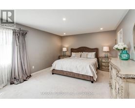 A bedroom with a large bed, a dresser, and a mirror.