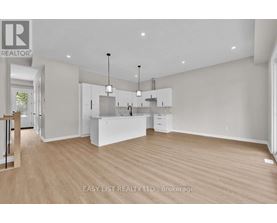 A spacious, empty room with wooden floors and white walls.