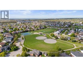 A bird's eye view of a residential area with a park and a pool.