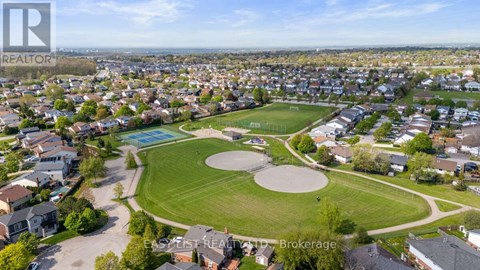 A bird's eye view of a residential area with a park and a pool.