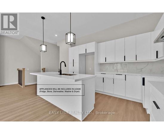 A modern kitchen with white cabinets and a marble backsplash is on the market.