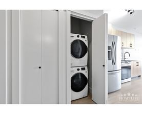 A white laundry room with a washer and dryer in it.