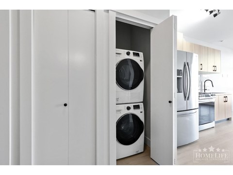 A white laundry room with a washer and dryer in it.