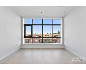 A large empty room with a view of a building outside the window.
