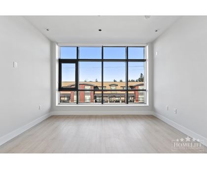 A large empty room with a view of a building outside the window.