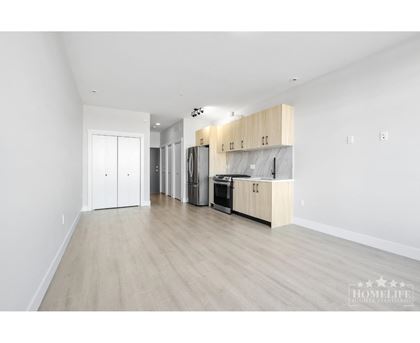 A kitchen with white cabinets and a wooden countertop.
