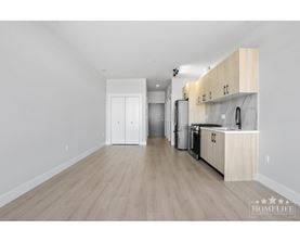 A kitchen with wooden floors and white walls.